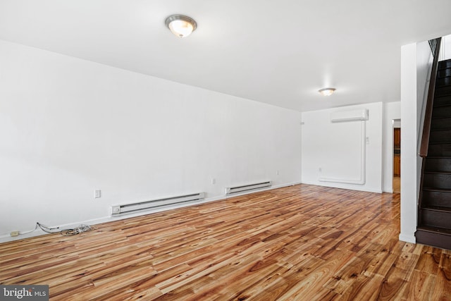 3545 Emerald St, Philadelphia, PA 19134 - unfurnished living room with a baseboard heating unit, an AC wall unit, wood finished floors, and stairway
