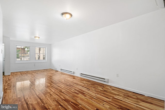 3545 Emerald St, Philadelphia, PA 19134 - unfurnished living room featuring baseboard heating, wood finished floors, and baseboards