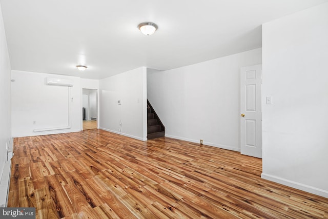 3545 Emerald St, Philadelphia, PA 19134 - unfurnished room featuring wood finished floors, stairs, a wall mounted air conditioner, and baseboards