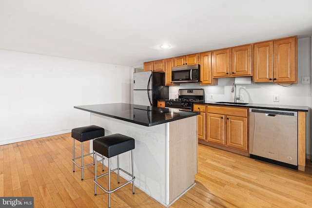 810 N Hancock St Unit 2, Philadelphia, PA 19123 - kitchen with stainless steel appliances, a kitchen bar, light wood-type flooring, dark countertops, and recessed lighting