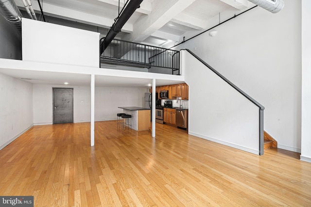 810 N Hancock St Unit 2, Philadelphia, PA 19123 - unfurnished living room featuring a high ceiling, stairway, and light wood finished floors