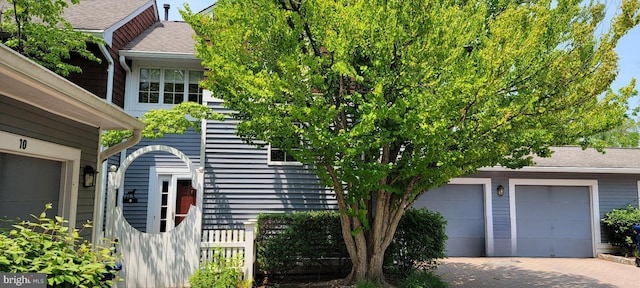 8 Railroad Pl, Pennington, NJ 08534 - view of side of home with decorative driveway, a garage, and roof with shingles