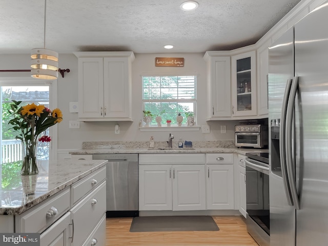 26055 Prospect Hill Rd, Mechanicsville, MD 20659 - kitchen featuring stainless steel appliances, a textured ceiling, a sink, white cabinetry, and light wood finished floors