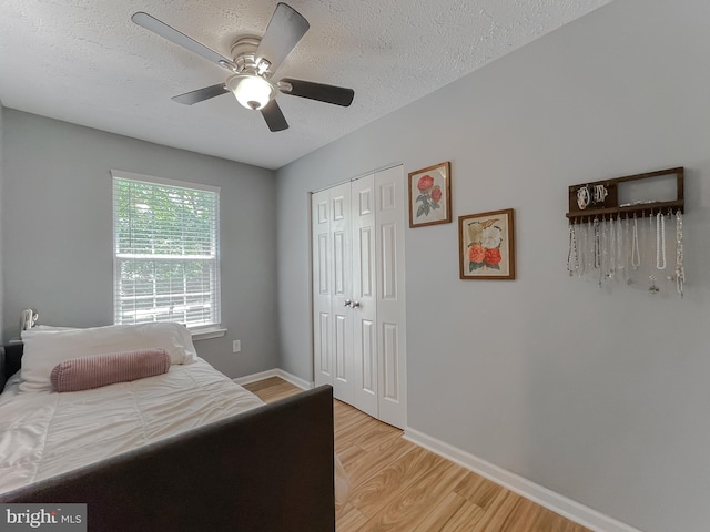 26055 Prospect Hill Rd, Mechanicsville, MD 20659 - bedroom with light wood-style floors, a closet, baseboards, a textured ceiling, and ceiling fan