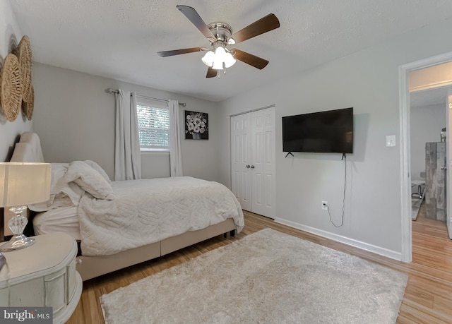 26055 Prospect Hill Rd, Mechanicsville, MD 20659 - bedroom featuring wood finished floors, a closet, baseboards, a ceiling fan, and a textured ceiling