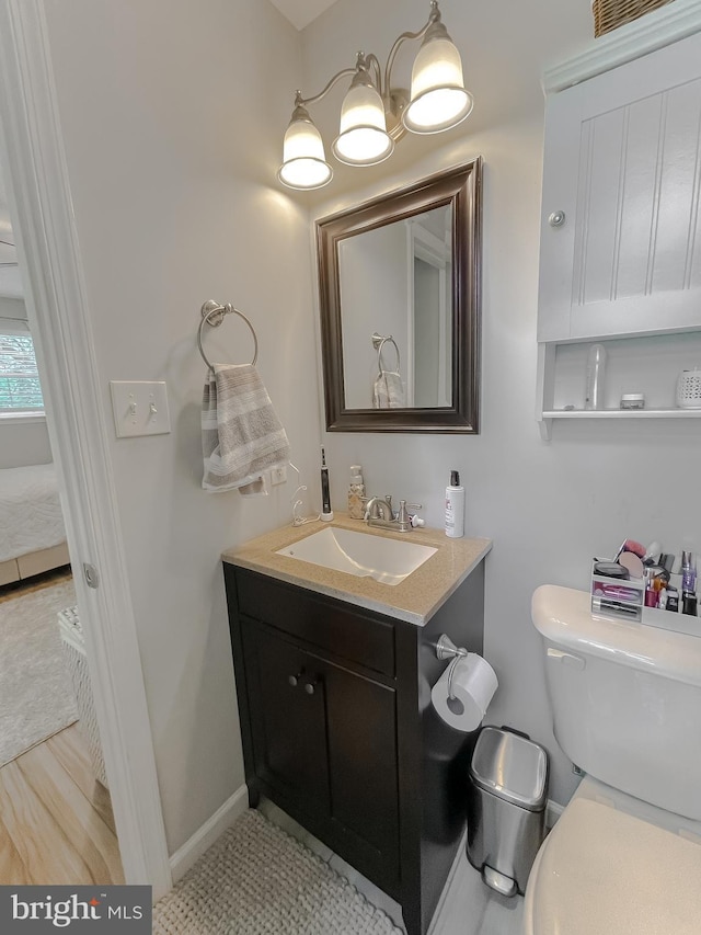 26055 Prospect Hill Rd, Mechanicsville, MD 20659 - half bathroom featuring toilet, vanity, baseboards, and ensuite bath