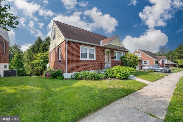 328 W Summit St, Mohnton, PA 19540 - view of front facade with brick siding, a front yard, cooling unit, and a shingled roof