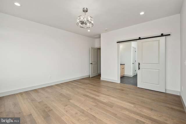 135 Radnor Ct, Rockingham, VA 22801 - unfurnished bedroom with a barn door, light wood-type flooring, a chandelier, recessed lighting, and baseboards