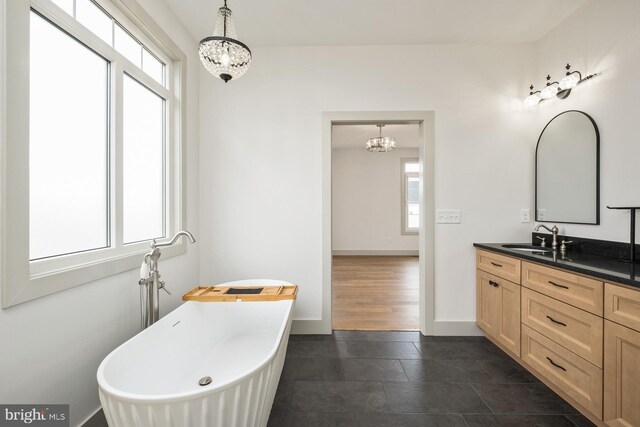 135 Radnor Ct, Rockingham, VA 22801 - bathroom with a chandelier, a freestanding bath, vanity, baseboards, and tile patterned floors