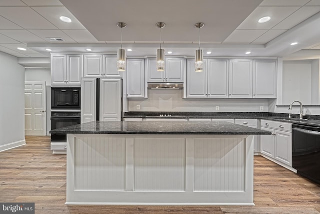 1637 Cold Bottom Rd, Sparks Glencoe, MD 21152 - kitchen with black appliances, a sink, a kitchen island, under cabinet range hood, and light wood finished floors