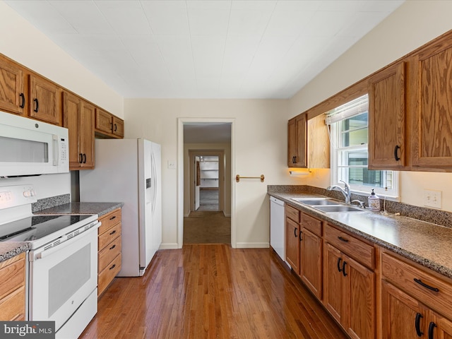 310 Bethel Rd, Paw Paw, WV 25434 - kitchen with white appliances, wood finished floors, brown cabinets, a sink, and dark countertops
