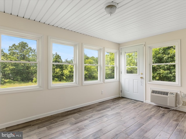 310 Bethel Rd, Paw Paw, WV 25434 - unfurnished sunroom with a wall unit AC, baseboards, wood finished floors, and a deck
