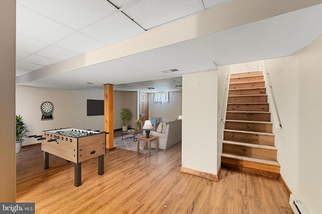 310 Bethel Rd, Paw Paw, WV 25434 - game room with a drop ceiling, a baseboard heating unit, light wood-type flooring, and baseboards