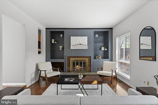 11866 S Lakes Ct, Reston, VA 20191 - living room featuring built in shelves, a glass covered fireplace, and wood finished floors
