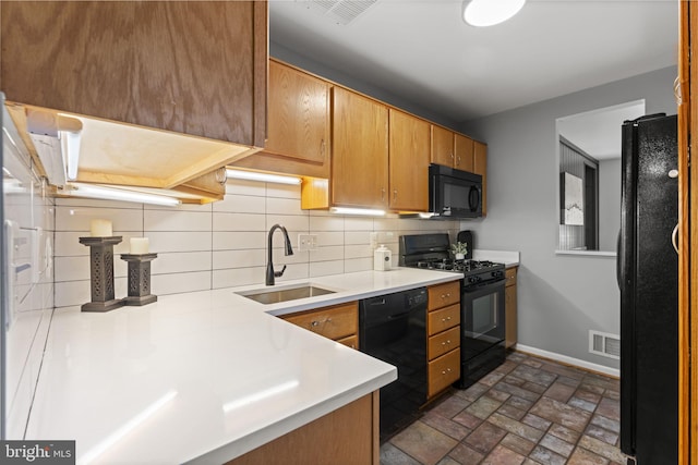 11866 S Lakes Ct, Reston, VA 20191 - kitchen featuring black appliances, light countertops, decorative backsplash, brick patterned floors, and brown cabinets