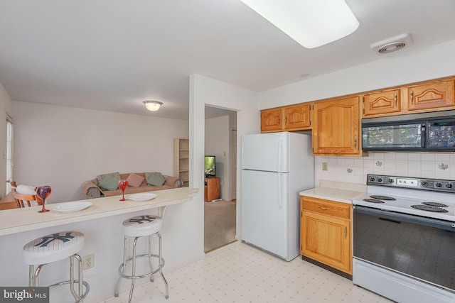 197 Victoria Ct, Doylestown, PA 18901 - kitchen with range with electric cooktop, freestanding refrigerator, black microwave, a breakfast bar area, and light flooring