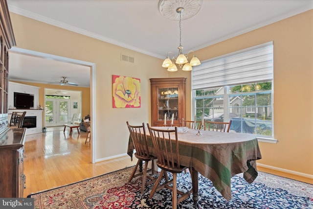 151 Lattice Ln, Collegeville, PA 19426 - dining room featuring a chandelier, ornamental molding, light wood-style floors, a fireplace, and ceiling fan