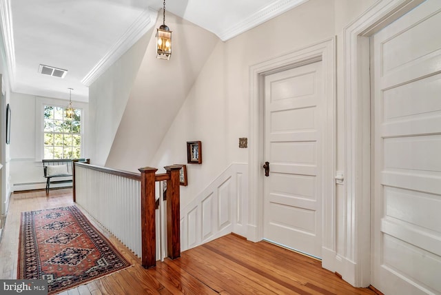 35175 Snickersville Tpke, Round Hill, VA 20141 - hallway with an upstairs landing, light wood-style flooring, a baseboard heating unit, crown molding, and a chandelier