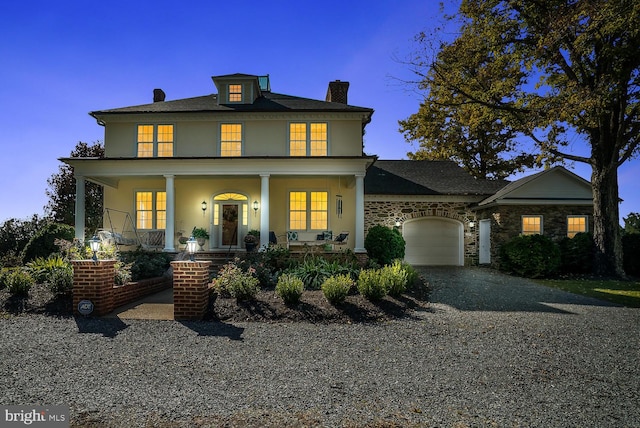 35175 Snickersville Tpke, Round Hill, VA 20141 - view of front facade featuring gravel driveway, a garage, a chimney, stucco siding, and a porch
