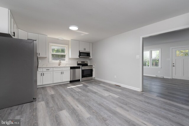 3220 Dupuy Rd, Colonial Heights, VA 23834 - kitchen with appliances with stainless steel finishes, light wood-style flooring, white cabinetry, and plenty of natural light