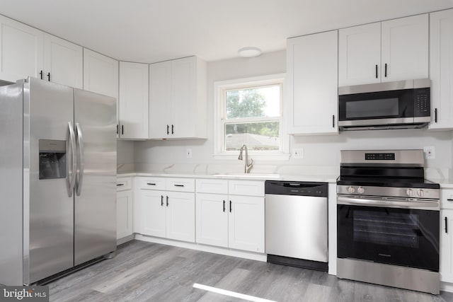 3220 Dupuy Rd, Colonial Heights, VA 23834 - kitchen with appliances with stainless steel finishes, a sink, light wood-style flooring, white cabinetry, and light stone countertops