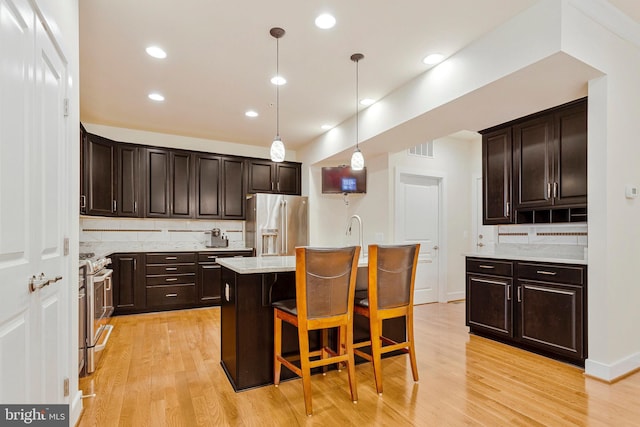 9726 Knowledge Dr, Laurel, MD 20723 - kitchen featuring stainless steel appliances, decorative backsplash, dark brown cabinetry, light wood-style floors, and recessed lighting