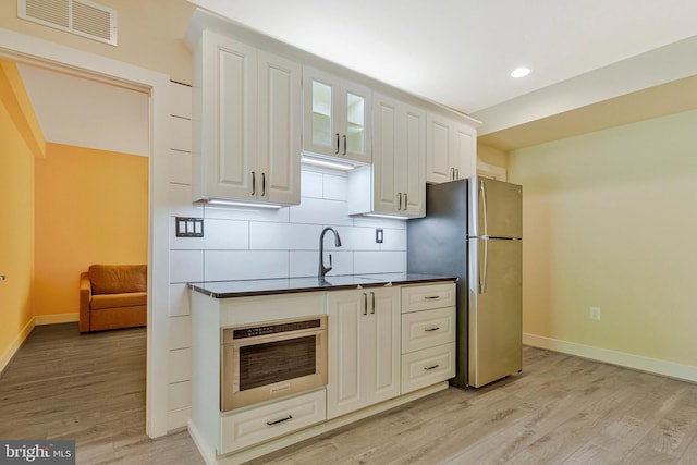 9726 Knowledge Dr, Laurel, MD 20723 - kitchen with stainless steel appliances, dark countertops, light wood-style flooring, baseboards, and recessed lighting