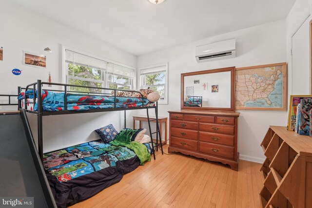 1323 Dorchester Ave, Gwynn Oak, MD 21207 - bedroom featuring an AC wall unit, light wood-style floors, and baseboards