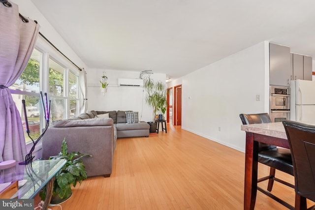 1323 Dorchester Ave, Gwynn Oak, MD 21207 - living room with a wall mounted air conditioner, light wood-type flooring, and baseboards