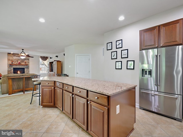 15446 Symondsbury Way, Upper Marlboro, MD 20774 - kitchen featuring high end refrigerator, a center island, light tile patterned flooring, light stone counters, and open floor plan