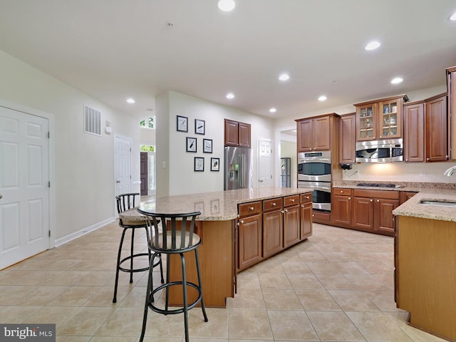 15446 Symondsbury Way, Upper Marlboro, MD 20774 - kitchen featuring appliances with stainless steel finishes, a sink, a kitchen island, light tile patterned floors, and light stone counters
