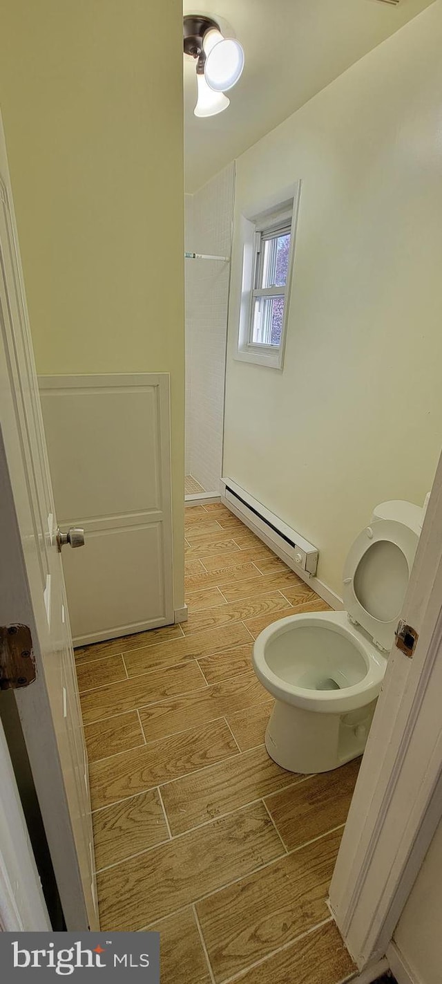 3063 Joyce St, Philadelphia, PA 19134 - bathroom with baseboard heating, wood finished floors, toilet, and a shower