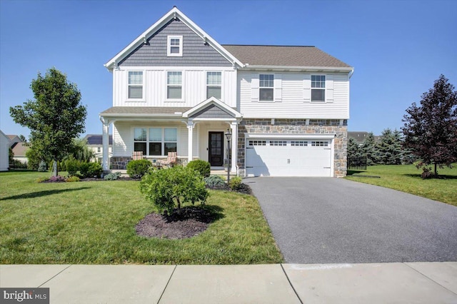 21 Bayberry Rd, Carlisle, PA 17013 - view of front of house featuring stone siding, a garage, driveway, a front lawn, and board and batten siding