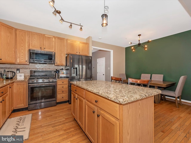 6529 Carston Ct, Frederick, MD 21703 - kitchen featuring stainless steel appliances, light wood-style flooring, tasteful backsplash, and a chandelier