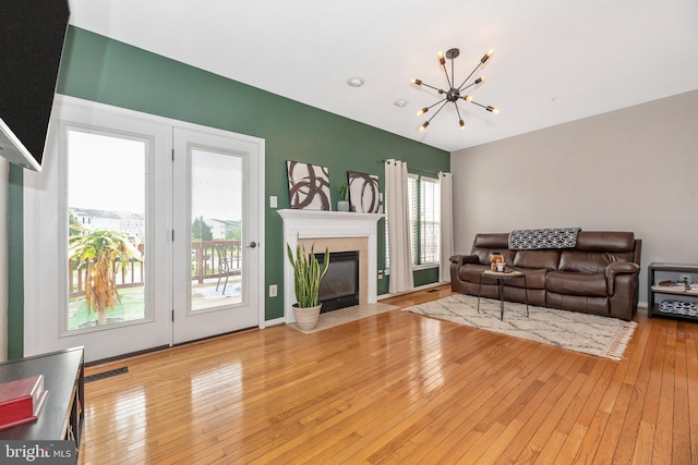 6529 Carston Ct, Frederick, MD 21703 - living room with a chandelier, hardwood / wood-style floors, and a fireplace with flush hearth