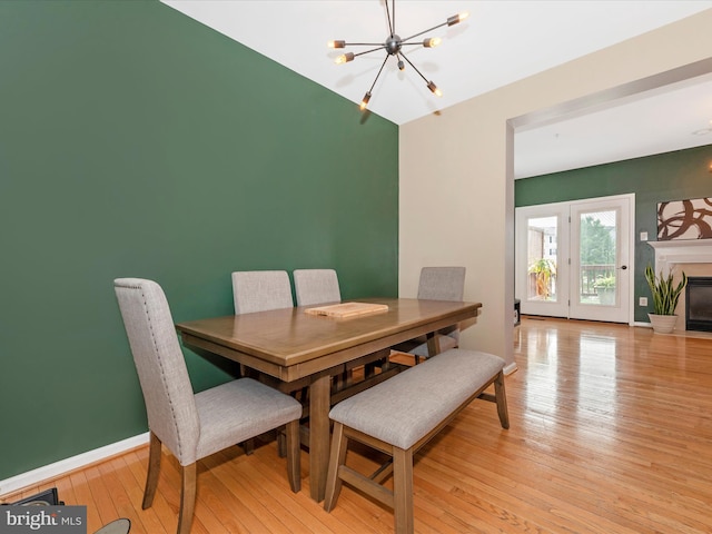 6529 Carston Ct, Frederick, MD 21703 - dining space featuring a chandelier, hardwood / wood-style flooring, and a glass covered fireplace