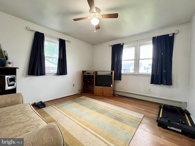 838 N Hanover St, Pottstown, PA 19464 - living room featuring a baseboard heating unit, light wood-type flooring, a ceiling fan, and baseboards