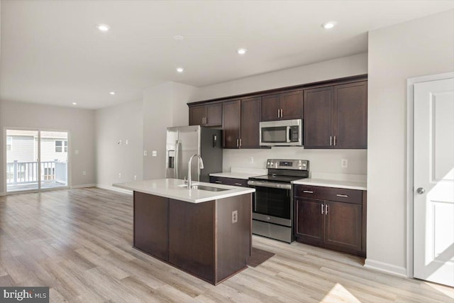 64 Anthem St, Ranson, WV 25438 - kitchen with appliances with stainless steel finishes, a sink, dark brown cabinetry, light wood-style floors, and light countertops