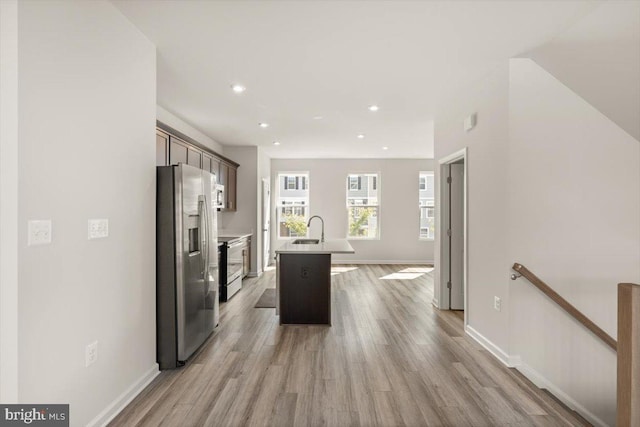 64 Anthem St, Ranson, WV 25438 - kitchen featuring appliances with stainless steel finishes, a sink, light wood-style flooring, a kitchen island with sink, and light countertops