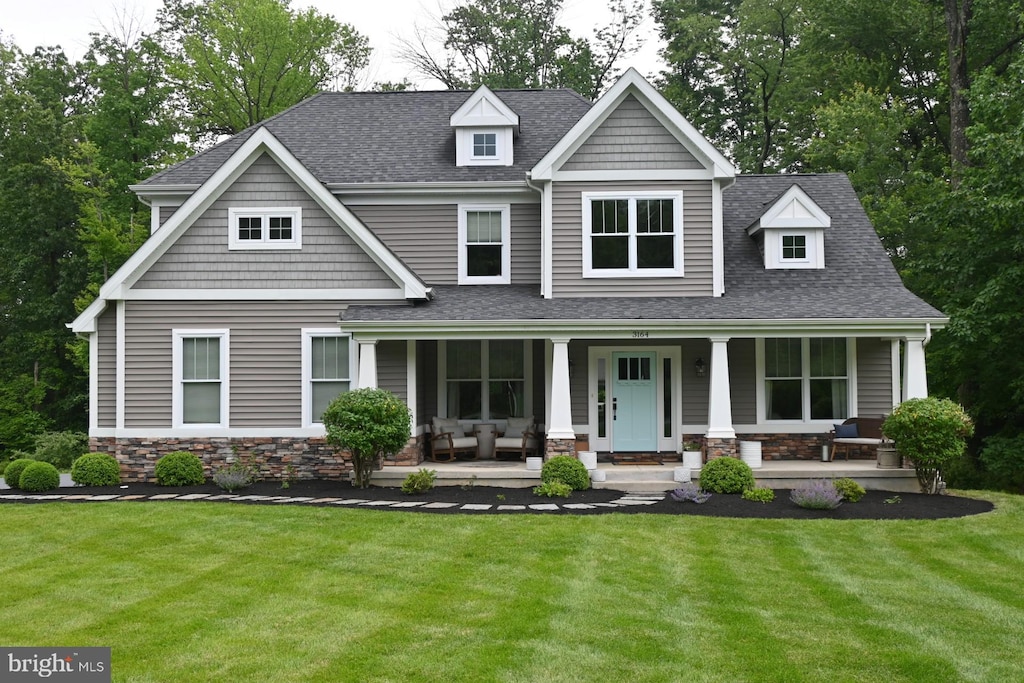 3164 Laughead Ln, Garnet Valley, PA 19060 - view of front of home featuring a porch, stone siding, a front yard, and roof with shingles