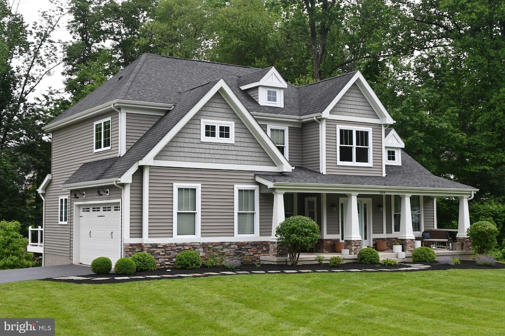 3164 Laughead Ln, Garnet Valley, PA 19060 - craftsman-style home featuring an attached garage, a porch, roof with shingles, and a front yard