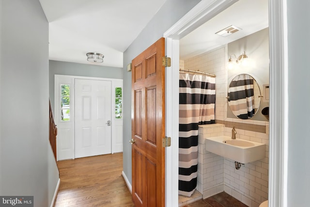 6082 Drum Point Rd, Deale, MD 20751 - full bathroom with wood finished floors, curtained shower, tile walls, and backsplash