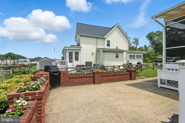 6082 Drum Point Rd, Deale, MD 20751 - rear view of house with a storage unit, a patio area, and roof with shingles