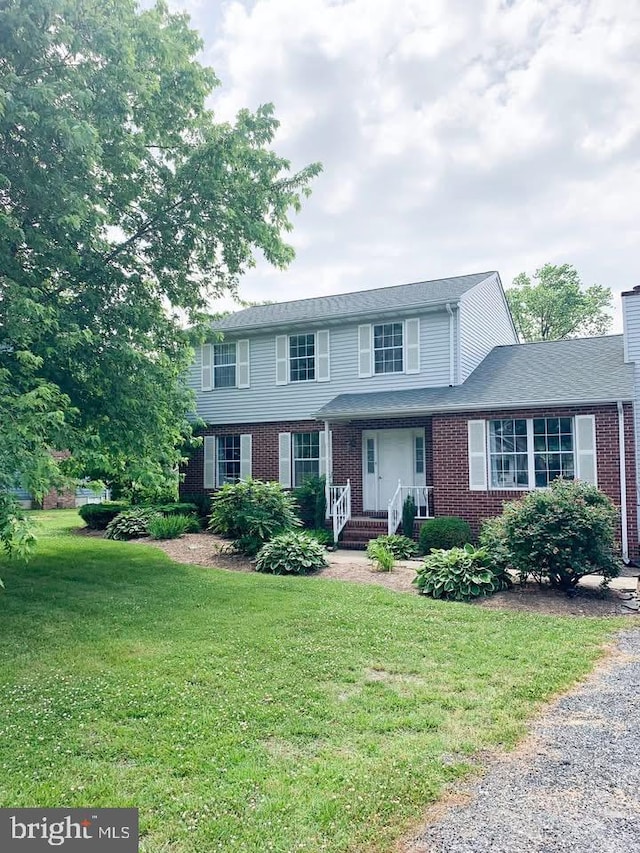 6082 Drum Point Rd, Deale, MD 20751 - view of front facade featuring brick siding, a front lawn, and a chimney