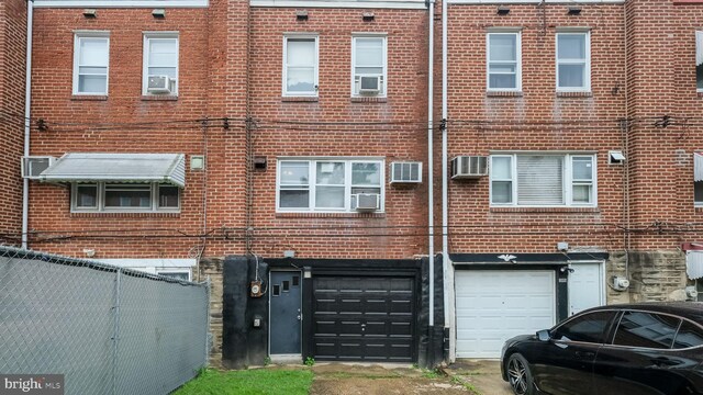 6254 Marsden St, Philadelphia, PA 19135 - back of property with an attached garage, brick siding, driveway, and cooling unit