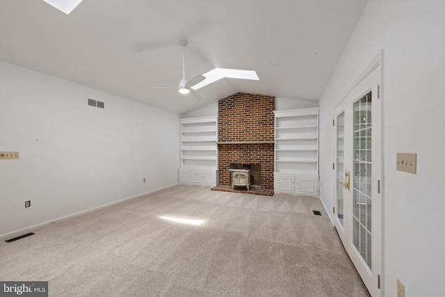 6 Constantine Dr, Phoenix, MD 21131 - unfurnished living room with a skylight, lofted ceiling, built in shelves, ceiling fan, and a wood stove