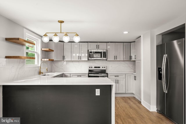 8255 Mertztown Rd, Alburtis, PA 18011 - kitchen with appliances with stainless steel finishes, a sink, a peninsula, open shelves, and light wood-style floors