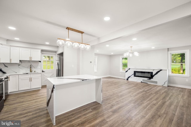 8255 Mertztown Rd, Alburtis, PA 18011 - kitchen with freestanding refrigerator, a kitchen island, wood finished floors, white cabinets, and recessed lighting