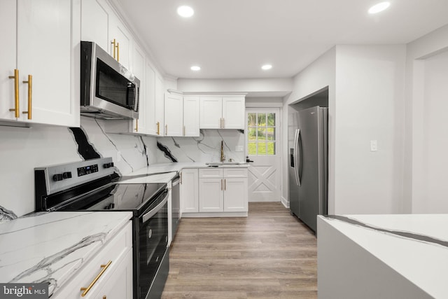 8255 Mertztown Rd, Alburtis, PA 18011 - kitchen with appliances with stainless steel finishes, light wood-style flooring, white cabinetry, recessed lighting, and light stone countertops