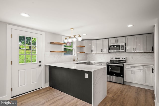 8255 Mertztown Rd, Alburtis, PA 18011 - kitchen with appliances with stainless steel finishes, open shelves, a sink, a peninsula, and light wood finished floors